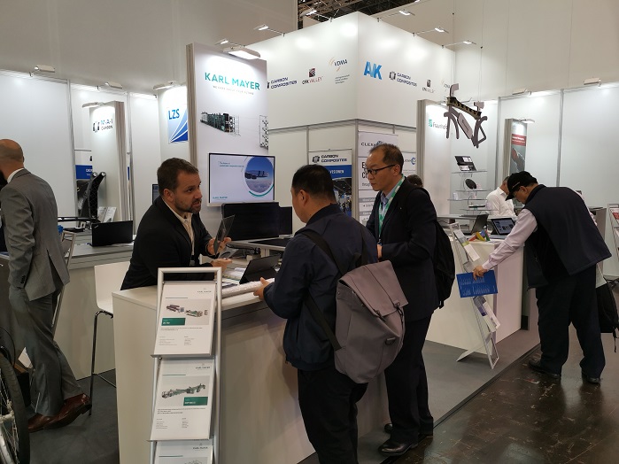 Intensive discussions at Karl Mayer's stand during K 2019. © Karl Mayer